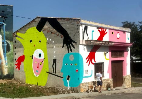 ‘Los Sin Nombre’, 2023, acrylic on concrete and brick wall, 6 x 17.4 m, front
