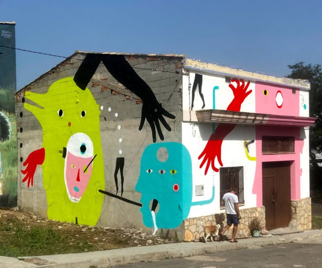 ‘Los Sin Nombre’, 2023, acrylic on concrete and brick wall, 6 x 17.4 m, front